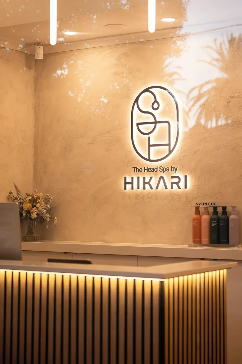 The reception desk at Hikari, with the Hikari logo lit on the wall behind it