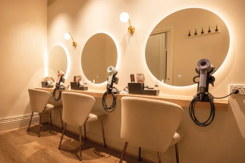 The Drying Studio at Hikari: round mirrors, wall lights, hairdryers and chairs along one wall