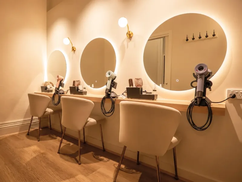 The Drying Studio at Hikari: round mirrors, wall lights, hairdryers and chairs along one wall